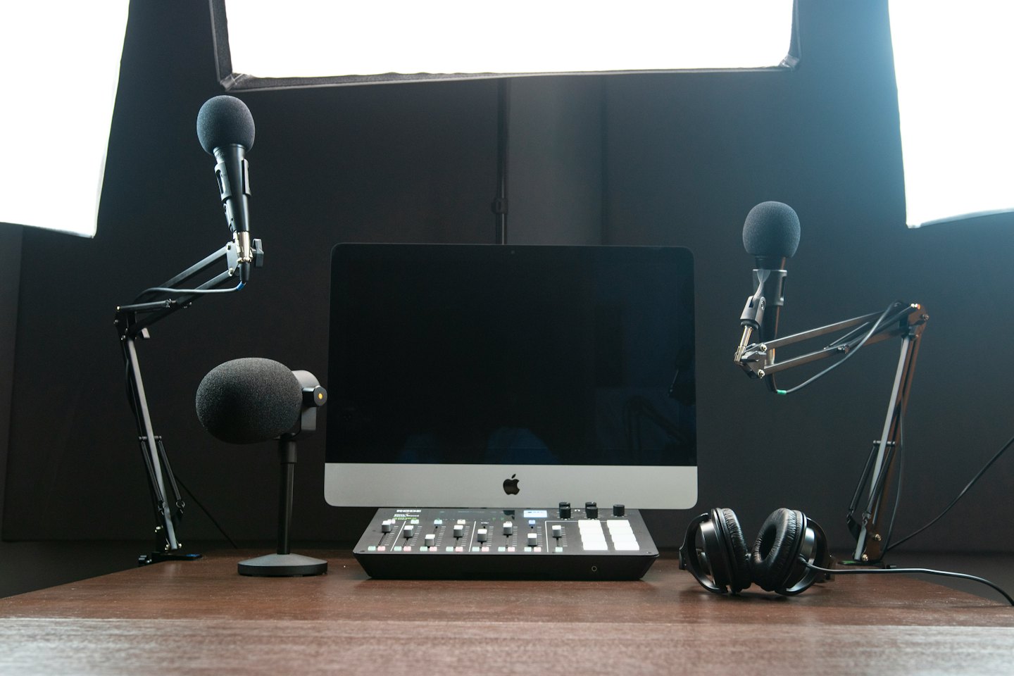 Podcast-Aufnahme-Setup mit Mikrofonen und Kopfhörern auf einem Schreibtisch.