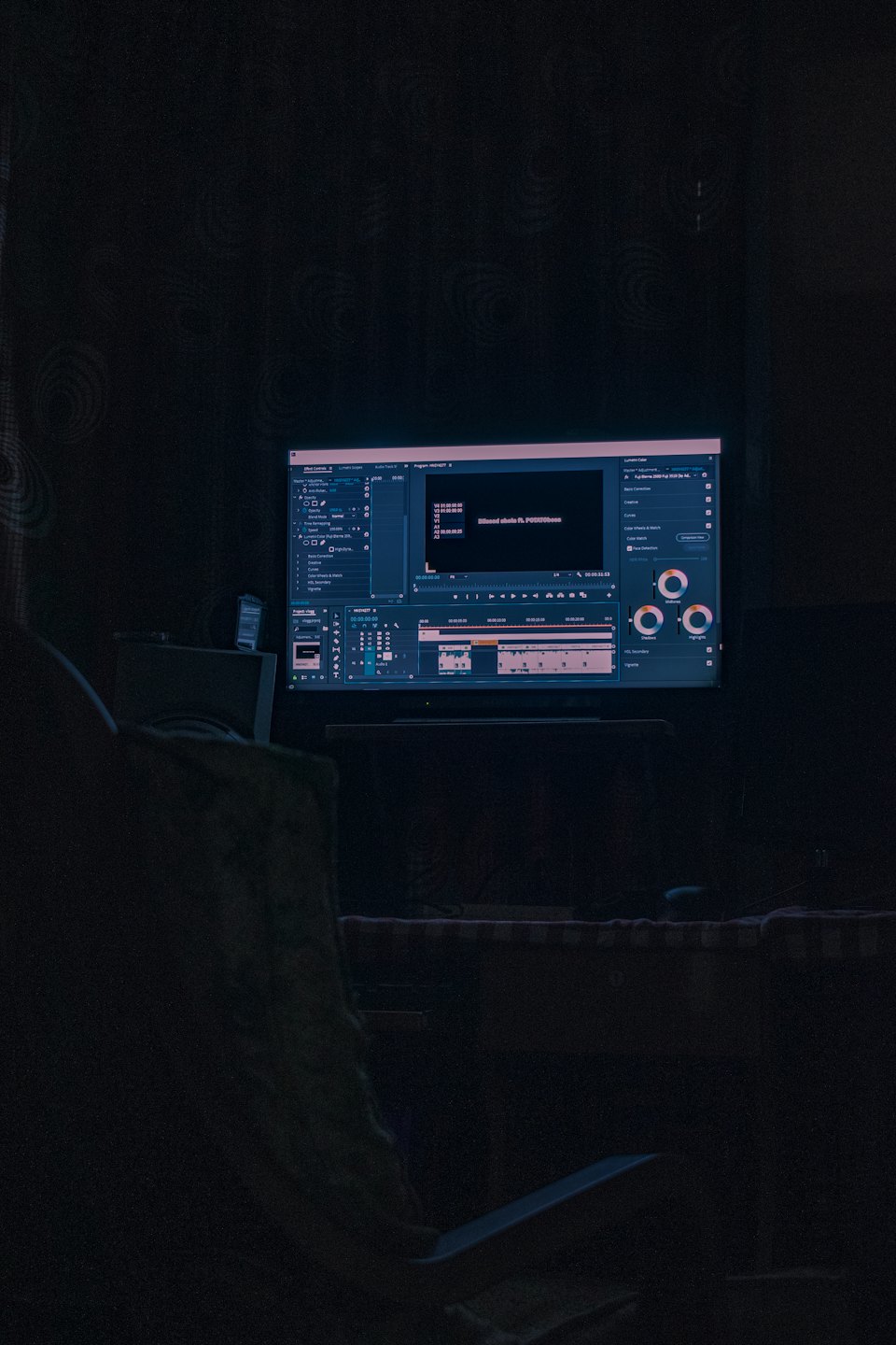 Computerbildschirm mit Videobearbeitungssoftware in einem dunklen Raum.